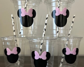以下が含まれることがあります： 黒と白のストライプのストローが付いた透明なプラスチックカップが6個。各カップには、ピンクのリボンが付いた黒と白のミニーマウスのステッカーが貼られています。