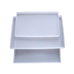 May include: Three white silicone trays of different sizes stacked on top of each other. The trays are rectangular and have a smooth surface.