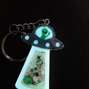 U.F-Uh-Oh! Ciondolo a forma di UFO luminoso: alieno rapinatore, ufo spaziale, disco volante, cliché retrò, carino, fantastico, UV, fosforescente al buio
