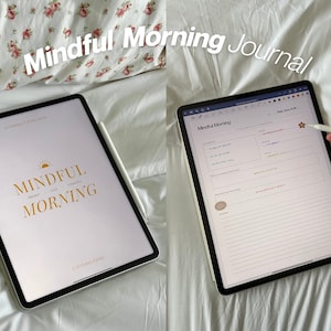 Op de afbeelding: Een digitale tablet met een mindful morning journal-app. De app heeft een witte achtergrond met een gouden zon-afbeelding en de tekst "Mindful Morning". De tablet ligt op een wit beddengoed met een bloemenpatroon.