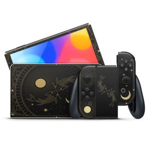Może przedstawiać: Czarna konsola Nintendo Switch z czarno-złotym wzorem o tematyce kosmicznej z gwiazdami, księżycami i rybami. Konsola jest pokazana z dopasowanym kontrolerem Joy-Con.