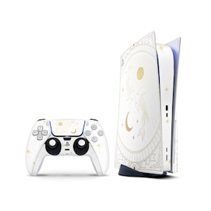 Może przedstawiać: Biały zestaw konsoli i kontrolera PlayStation 5 ze złotym niebiańskim wzorem przedstawiającym ryby, księżyce, słońca i gwiazdy. Kontroler ma niebieskie akcenty. Konsola stoi na czarnej podstawie.