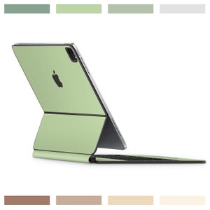 Può includere: Un iPad Pro verde chiaro con una custodia per tastiera abbinata. L'iPad è chiuso e la tastiera è ripiegata.