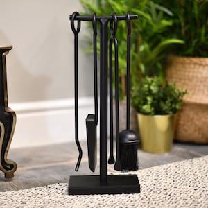 May include: Black metal fireplace tool set with a stand. The set includes a poker, shovel, tongs, and brush.