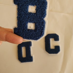 May include: Three blue felt letter patches, a large "B", a smaller "C", and a smaller "D".