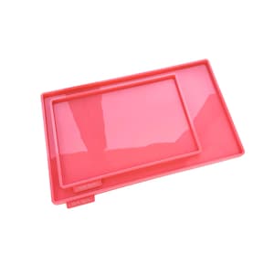 May include: Two rectangular pink silicone moulds with raised edges, nested one inside the other. Each mould features a small tab on the side with the embossed text "Melle Melle" visible on the surface of the silicone material.