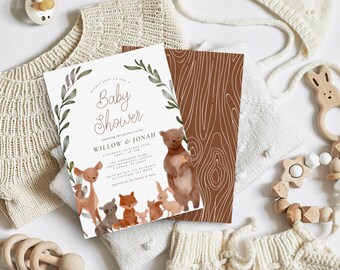 May include: A white baby shower invitation with a leafy border and a watercolor illustration of woodland animals, including a deer, a bear, a fox, a rabbit, and a squirrel. The text on the invitation reads "Baby Shower" and "honoring the parents-to-be Willow & Jonah".