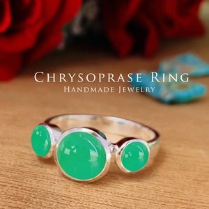 May include: A silver ring with three green chrysoprase stones. The ring is handmade jewelry.