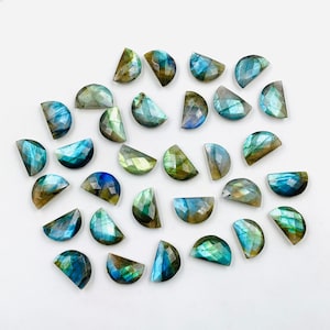 Puede incluir: Una colección de 25 cabujones de labradorita de media luna iridiscentes. Las piedras son una mezcla de colores azules, verdes y dorados con un acabado iridiscente brillante.