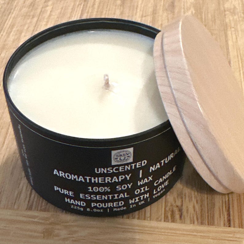 May include: A black candle jar with a wooden lid. The candle is unscented and made with 100% soy wax. The label reads "Unscented Aromatherapy Natural Pure Essential Oil Candle 100% Soy Wax Hand Poured With Love 225g 8.0oz | Made in UK | Vegan".