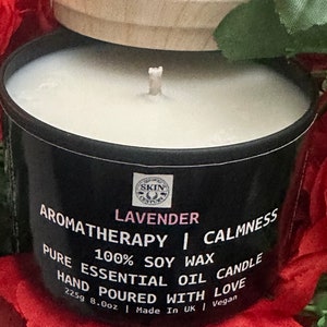May include: A black candle jar with a wooden lid. The label reads "LAVENDER AROMATHERAPY | CALMNESS PURE 100% SOY WAX CANDLE ESSENTIAL OIL HAND POURED WITH LOVE 225g 8.0oz | Made In UK | Vegan".