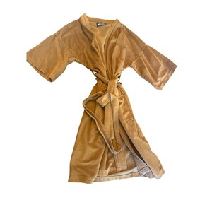 May include: A solid tan-colored robe featuring short sleeves, a wrap-around front design, and a matching fabric tie belt at the waist. The garment has a soft, textured appearance with a visible collar and a small dark label at the inner neckline.