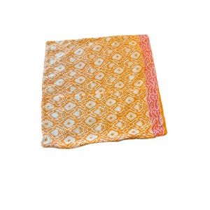 May include: A square throw pillow cover featuring a vibrant orange and white diamond-shaped geometric pattern across the main body. The right edge is finished with a contrasting vertical border in a lighter coral pink hue with white dots.