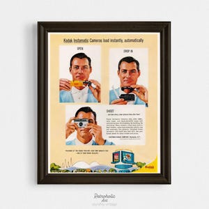 May include: A vintage Kodak Instamatic camera advertisement in a dark brown frame. The poster features three panels showing a person demonstrating how to open, drop in film, and shoot. It includes the text Kodak Instamatic Cameras load instantly, automatically, and features a graphic of the Kodak Pavilion at the New York World's Fair.