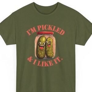 May include: A green t-shirt with the text "I'M PICKLED & I LIKE IT." in red. A cartoon image of two pickles in a jar with smiling faces is above the text.