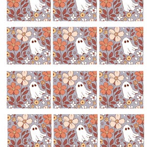 Puede incluir: Una hoja de doce etiquetas de regalo rectangulares con un patrón repetitivo de fantasmas blancos, flores naranjas y pequeñas flores blancas sobre un fondo morado claro. Cada etiqueta tiene un pequeño orificio en la parte superior para colgar.