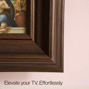 Op de afbeelding: Een ingelijst schilderij met een donkerbruine, getextureerde houten lijst. De schildering toont figuren in klassieke kledij. De tekst onderaan luidt "Elevate your TV, Effortlessly."