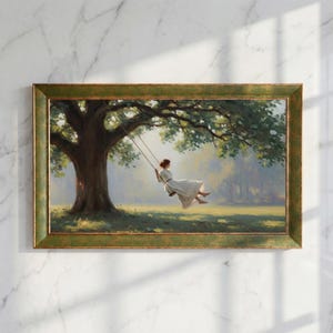 Pode incluir: Pintura emoldurada que retrata uma pessoa num baloiço sob uma grande árvore. A obra de arte apresenta uma pessoa com um vestido branco a balançar-se num prado ensolarado. A moldura é de cor verde desgastada, adicionando uma estética vintage.