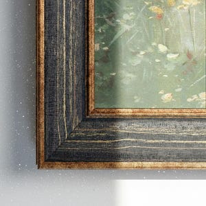 Könnte beinhalten: Gerahmtes Gemälde mit einem dunklen, strukturierten Holzrahmen. Der Rahmen hat eine schwarze Oberfläche mit goldenen Akzenten. Das Kunstwerk im Inneren zeigt eine weiche, impressionistische Landschaft mit grünen und gelben Farbtönen.