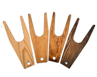 May include: Four wooden boot jacks in various shades of brown. The boot jacks are made of wood and have a simple design with a U-shaped opening.