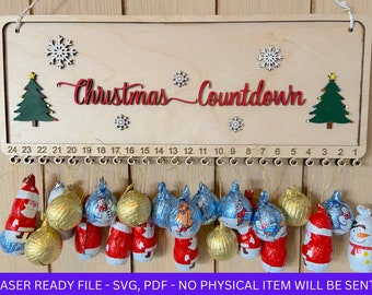 May include: A wooden Christmas countdown sign with 24 numbered hooks. The sign is decorated with snowflakes and Christmas trees. The text "Christmas Countdown" is written in red on the sign. The sign is laser cut and ready to be assembled.