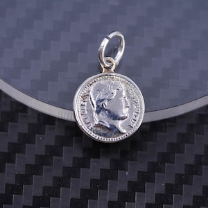 May include: Silver charm pendant featuring a profile of a man with the words "NAPOLEON EMPEREUR" around the edge.
