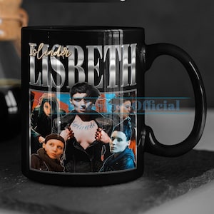 Peut inclure: Mug noir de 11 oz avec un collage d'images de personnages de la série télévisée "The Slander" avec le texte "The Slander LISBETH Official" imprimé sur la tasse.