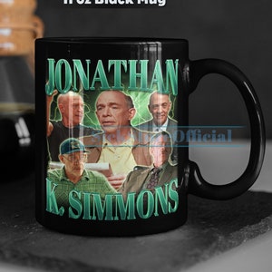 May include: Black 11 oz mug with a collage of photos of Jonathan K. Simmons. The mug has a green and white design with the text "Jonathan K. Simmons" in green.