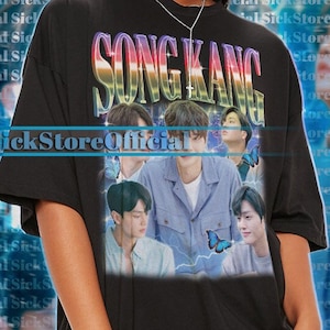 Könnte beinhalten: Schwarzes Oversize-T-Shirt mit einem Grafikdruck einer Gruppe von Männern mit Schmetterlingen und dem Text "SONG KANG" in Regenbogenfarben. Der Text "SickStoreOfficial" ist unter dem Grafikdruck gedruckt.