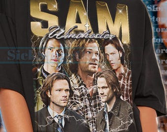 May include: Black t-shirt featuring a gold-colored "SAM Winchester" graphic with images of several men. The shirt has a vintage, distressed look. The text at the bottom says the shirt is unisex and true to size.