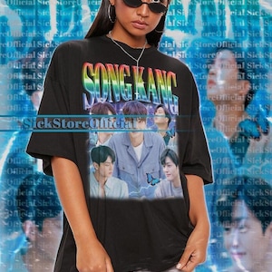 Könnte beinhalten: Schwarzes Unisex-T-Shirt mit dem Text "SONG KANG" in Regenbogenfarben und Bildern einer Person. Das T-Shirt wird von einer Person mit Sonnenbrille getragen.