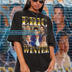 May include: Black unisex t-shirt featuring the name "ERIC WINTER" in gold lettering with a photo collage of several men. The shirt is worn by a person wearing sunglasses.