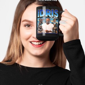 Puede incluir: Una taza negra de 15 onzas con un gr&aacute;fico de Idris Elba y el texto "Idris Elba".
