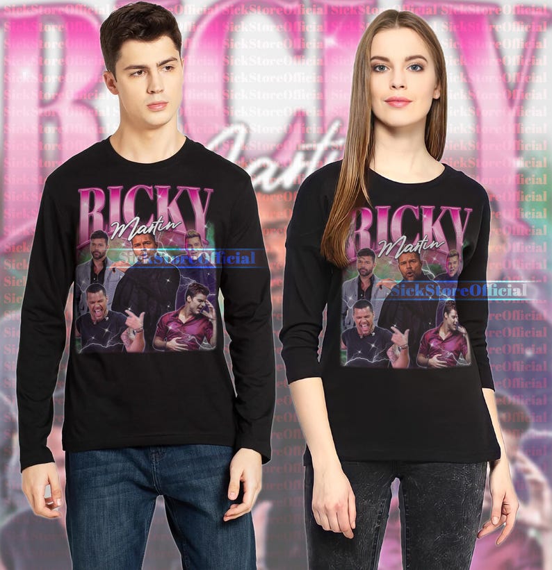 May include: Black long-sleeve shirts featuring a graphic of Ricky Martin with the text "Ricky Martin" in pink and white. The shirts have a crew neck and are worn by a man and a woman.