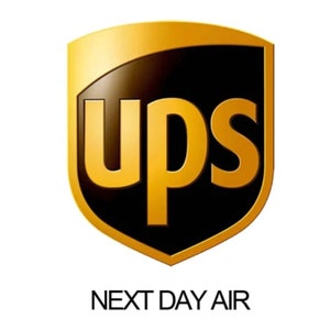 May include: The UPS logo, a shield shape in gold and black, with the letters "ups" in gold. Below the logo, the text "NEXT DAY AIR" is displayed in black.