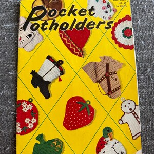 Pode incluir: Um livreto de instruções vintage intitulado Pocket Potholders, Star Book No. 69, 10 cents. A capa amarela brilhante apresenta um padrão de grade de diamante exibindo vários designs de pegadores de panela de crochê, incluindo um morango, uma cabeça de cavalo, uma bota e um pato.