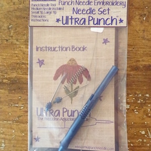 May include: A close-up of a punch needle embroidery kit with a blue tool, three needles, and an instruction booklet. The packaging is labeled "Ultra Punch* Needle Set" and includes instructions for using the tool.