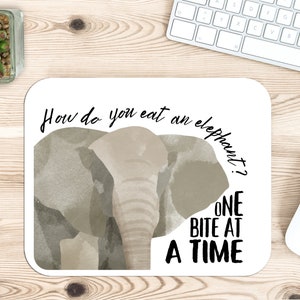 May include: A white mouse pad with a watercolor illustration of an elephant's head. The text "How do you eat an elephant? ONE BITE AT A TIME" is printed on the mouse pad.