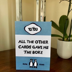 Tarjeta de felicitación con la portada del libro "Gave Me The Boke" (Me dio el Boke)