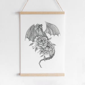 May include: Black and white line art print of a dragon with its wings spread out and its tail curled around a bouquet of flowers. The dragon is drawn in a detailed, stippled style.