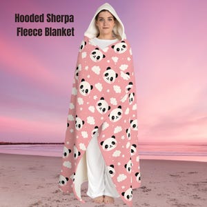 Wrap yourself in comfort with this cozy Hooded Sherpa Fleece Blanket, perfect for chilly evenings or lazy weekends at home. Designed with a charming panda print on a soft pink background, this blanket radiates a fun and comfy vibe that enhances your relaxation moments. Whether you're binge-watching your favorite show, reading a book, or enjoying a cozy night in, this blanket adds a touch of joy to your everyday life.