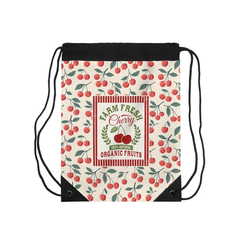May include: A drawstring bag with a cream-colored background covered in red cherry illustrations and green leaves. The center features a rectangular label with the text "Farm Fresh Cherry" and "100% Natural Organic Fruits."
