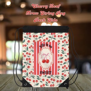 May include: Drawstring bag with a cherry leaf pattern and the text "Cherry Leaf Draw String Bag Back Side". The bag features a central design with red and pink stripes, the words "life is so sweet", and a cherry illustration.
