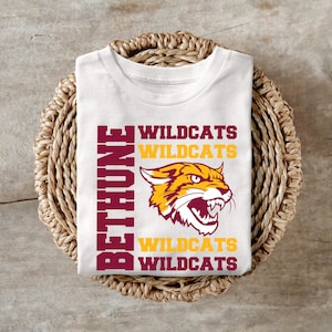 May include: White t-shirt with a maroon and gold graphic of a wildcat with the text "BETHUNE WILDCATS" repeated four times.