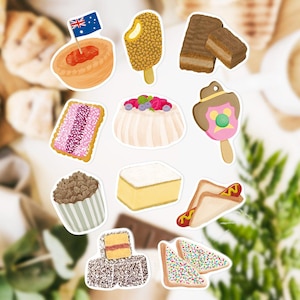 Op de afbeelding: Een verzameling kleurrijke Australische voedselstickers, waaronder een vleespastei met een vlag, ijs, gelaagde cake, een roze koekje met glazuur, pavlova en een hotdogsandwich. De stickers staan op een witte achtergrond.
