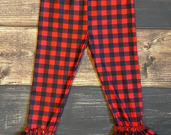 Puede incluir: Leggings de cuadros rojos y negros con dobladillo con volantes.