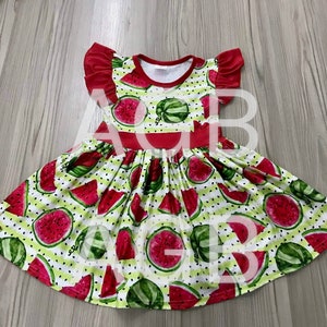 May include: A red and green sleeveless dress with a watermelon print. The dress has a ruffled neckline and a white background with green stripes and black polka dots.
