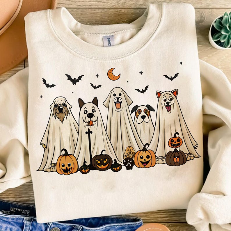 Pu&ograve; includere: Felpa color crema con un design di Halloween. La grafica mostra cinque cani vestiti da fantasmi, con zucche e pipistrelli. Sono inclusi anche una luna crescente e stelle. La felpa &egrave; a girocollo.