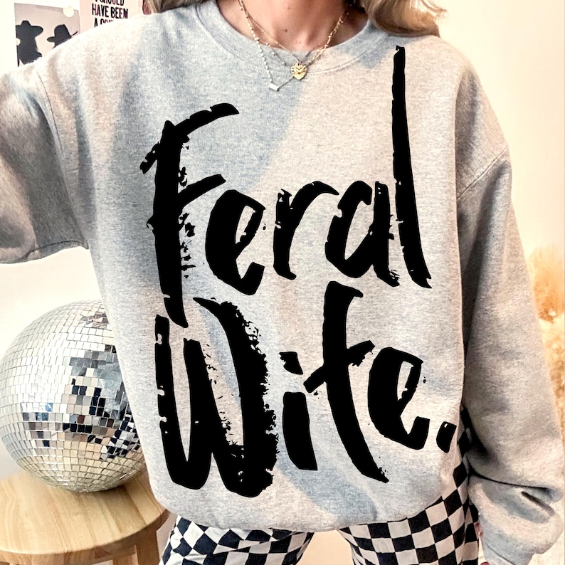 May include: A gray sweatshirt with the text "Feral Wife." printed in black.