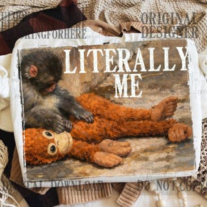 May include: White tote bag featuring a whimsical illustration of a monkey grooming an orangutan, with the text "LITERALLY ME" in bold letters. The artwork has a vintage, painterly style, with warm orange and brown tones.
